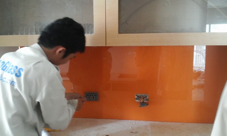 Thi công kính màu cam vàng ốp bếp